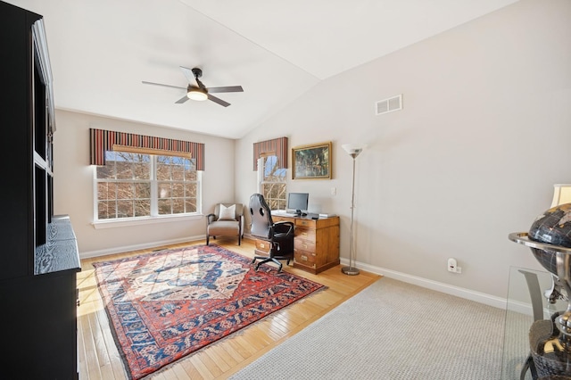 office space featuring wood-type flooring, visible vents, a ceiling fan, vaulted ceiling, and baseboards