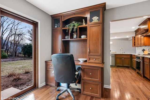 home office with a sink, recessed lighting, baseboards, and hardwood / wood-style floors