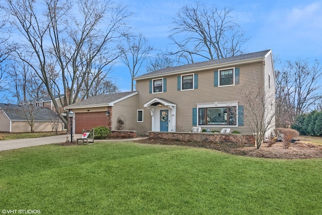 colonial home featuring driveway, an attached garage, and a front yard