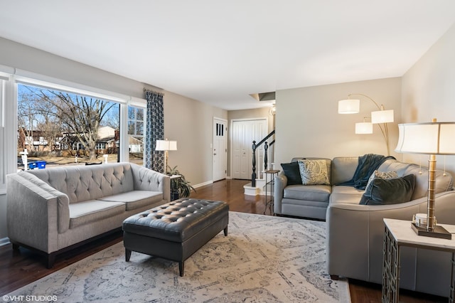 living area with stairway, baseboards, and wood finished floors