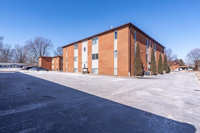 view of building exterior with a residential view and central AC unit