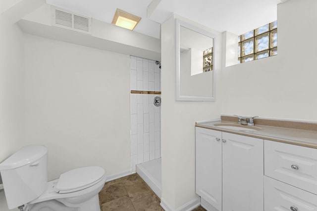 full bath featuring visible vents, toilet, vanity, tiled shower, and baseboards