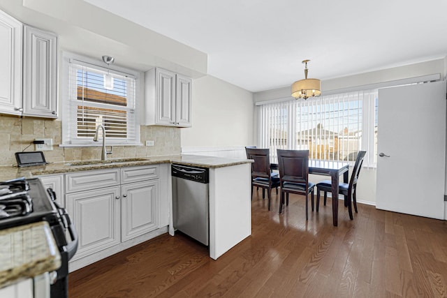 kitchen featuring white cabinets, a sink, decorative light fixtures, and dishwasher