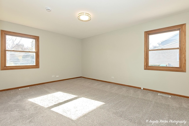 carpeted empty room with visible vents and baseboards