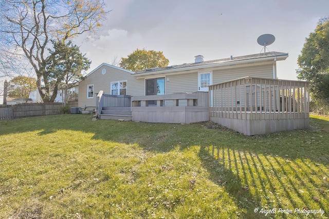 back of house with a lawn, a deck, and fence