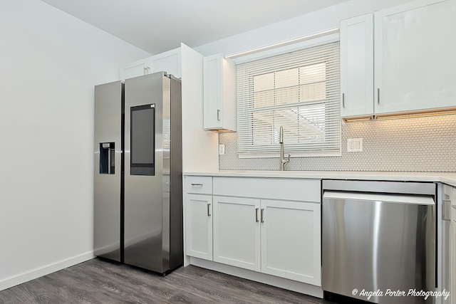 kitchen with a sink, white cabinets, light countertops, appliances with stainless steel finishes, and dark wood finished floors