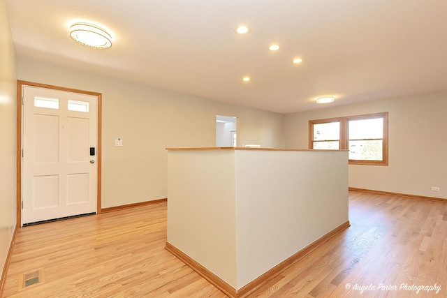 foyer featuring light wood finished floors, recessed lighting, visible vents, and baseboards