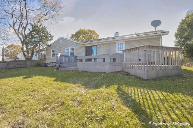 back of house with a lawn, a wooden deck, and fence