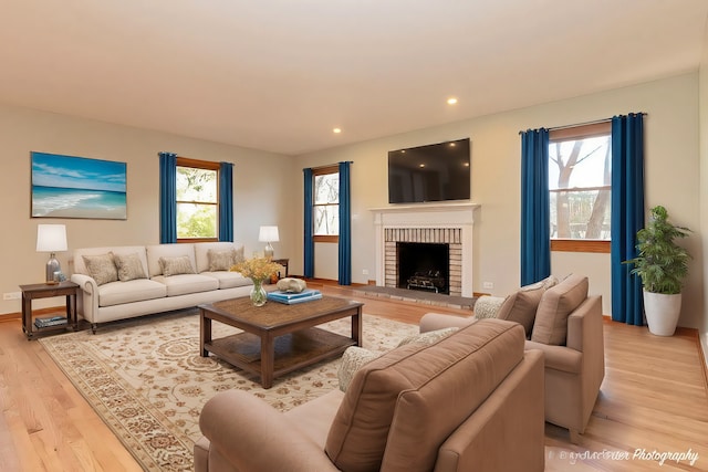 living area featuring light wood finished floors, a fireplace, and recessed lighting