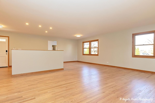 spare room with baseboards, recessed lighting, and light wood-style floors