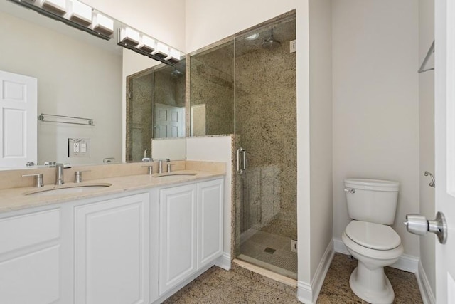 bathroom with a stall shower, a sink, toilet, and baseboards