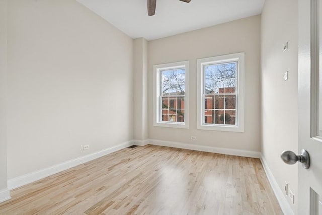 empty room with ceiling fan, wood finished floors, and baseboards