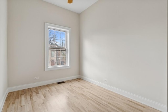 spare room with light wood-style floors, visible vents, baseboards, and ceiling fan