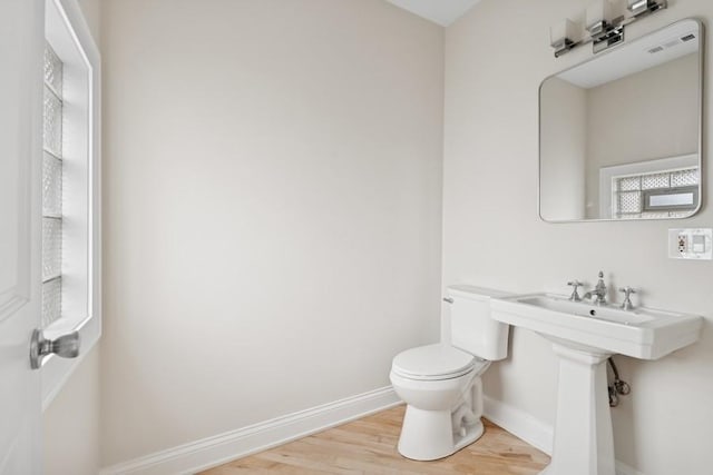 bathroom featuring visible vents, wood finished floors, toilet, and baseboards