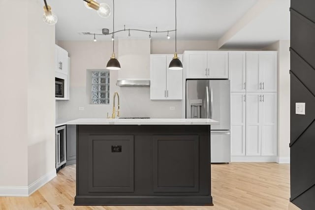 kitchen featuring light countertops, built in microwave, white cabinetry, and stainless steel refrigerator with ice dispenser