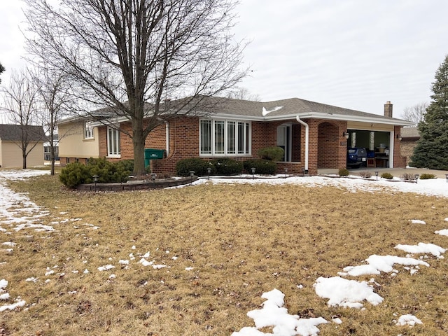 single story home featuring a garage, brick siding, and a chimney