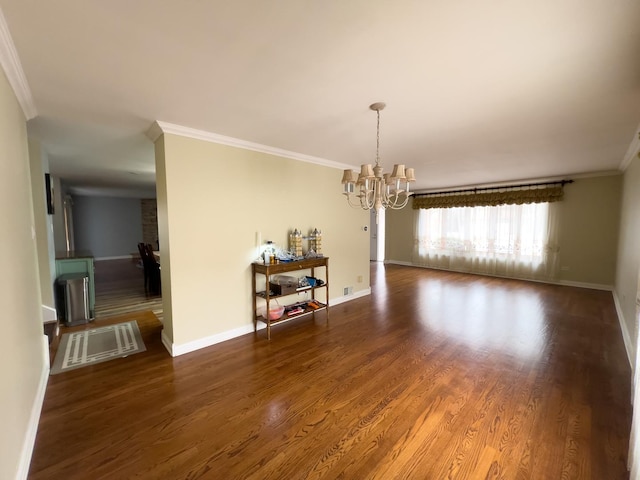 unfurnished dining area with dark wood-type flooring, ornamental molding, and an inviting chandelier