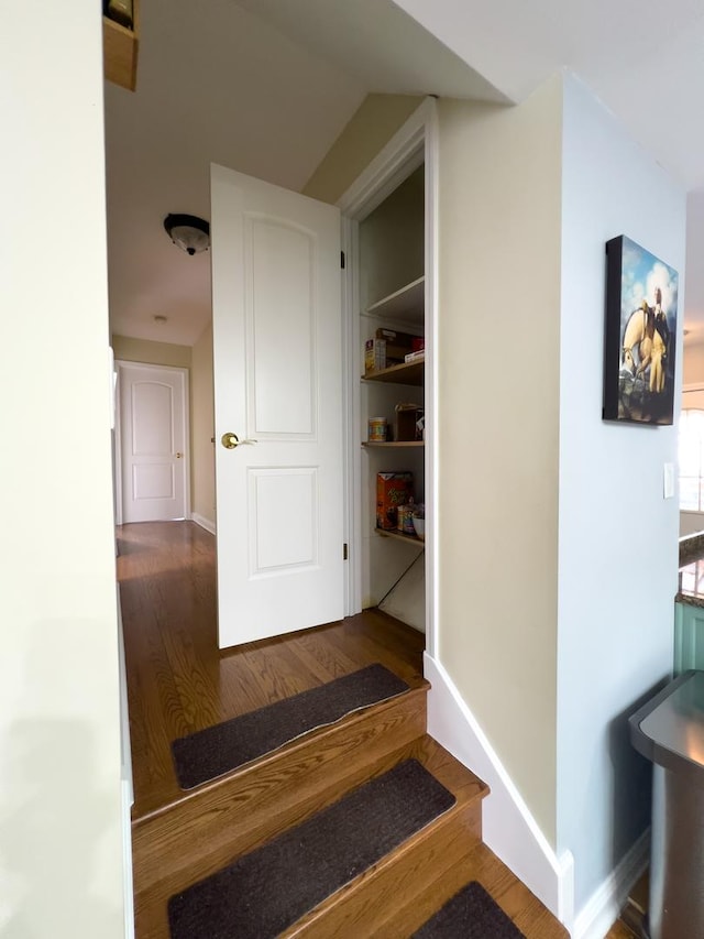 hall with stairway, wood finished floors, and baseboards