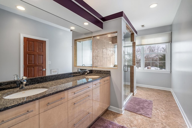 bathroom featuring double vanity, a sink, visible vents, and a shower stall