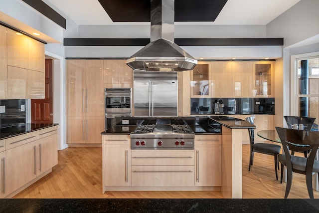 kitchen featuring stainless steel appliances, light brown cabinets, and island range hood