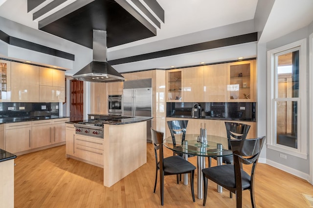 kitchen featuring a center island, island exhaust hood, stainless steel appliances, light brown cabinets, and modern cabinets