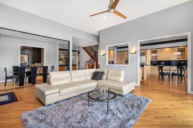 living area featuring light wood finished floors, ceiling fan, stairs, and recessed lighting