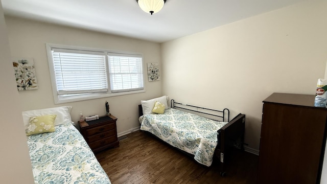 bedroom featuring visible vents, dark wood finished floors, and baseboards