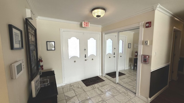 entryway featuring ornamental molding, french doors, marble finish floor, and baseboards