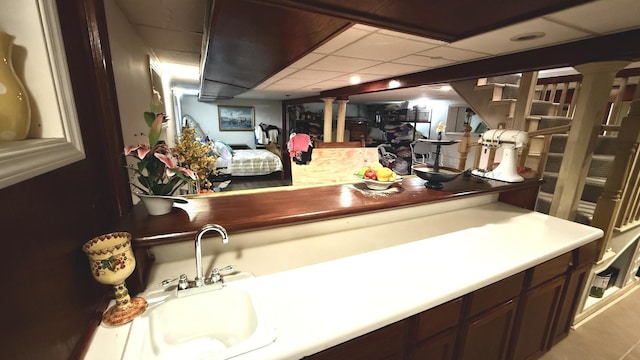 bathroom with a sink, ornate columns, and a drop ceiling