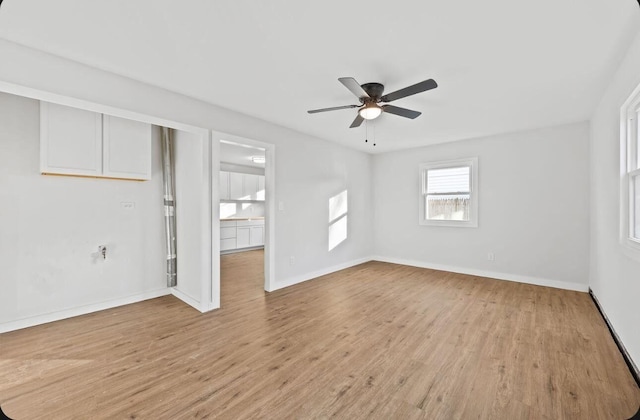 unfurnished room with light wood-style floors, ceiling fan, and baseboards