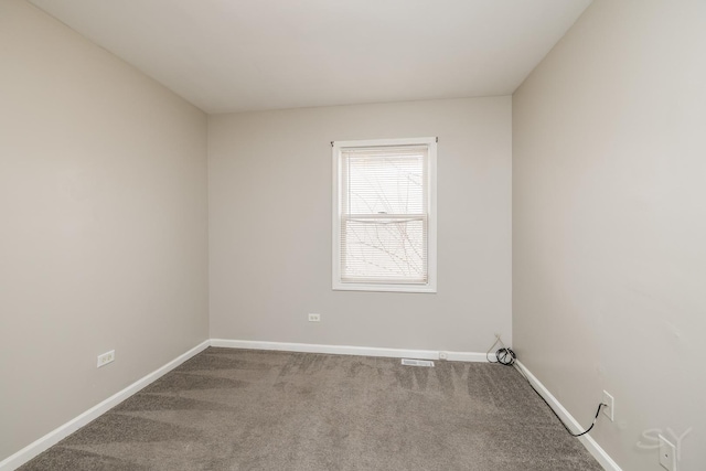 empty room with carpet flooring, visible vents, and baseboards