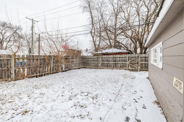 yard layered in snow featuring a fenced backyard