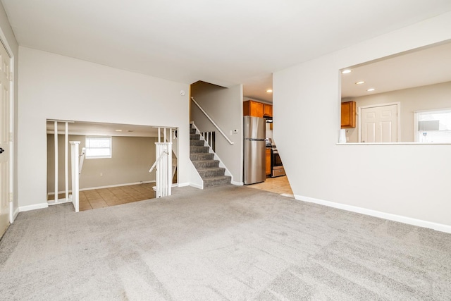 empty room featuring recessed lighting, baseboards, stairway, and light colored carpet