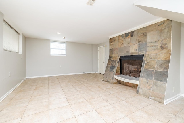 unfurnished living room featuring light tile patterned floors, baseboards, a fireplace, and visible vents