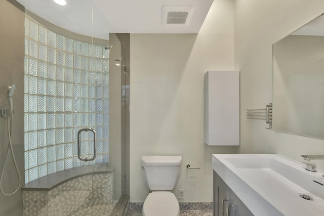 bathroom with toilet, vanity, a shower stall, and visible vents