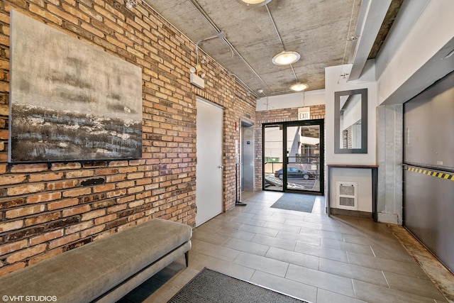 hall with brick wall and tile patterned flooring