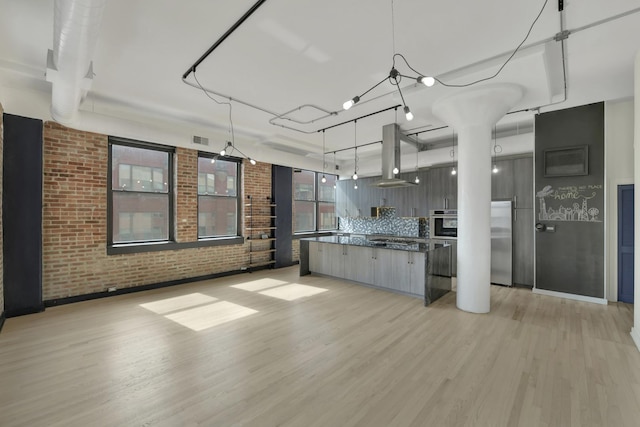 kitchen featuring pendant lighting, a spacious island, dark countertops, appliances with stainless steel finishes, and modern cabinets