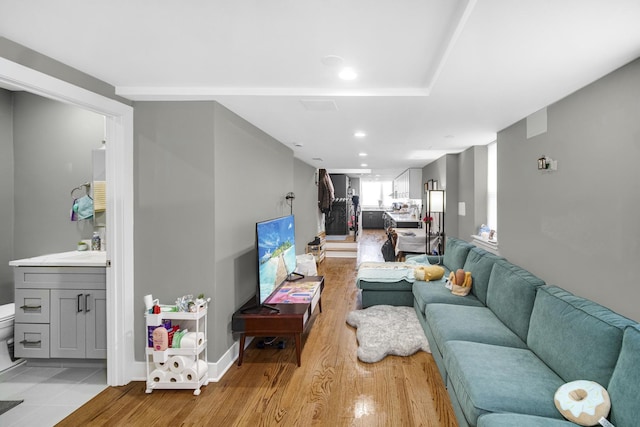 living room featuring baseboards, recessed lighting, and light wood-style floors