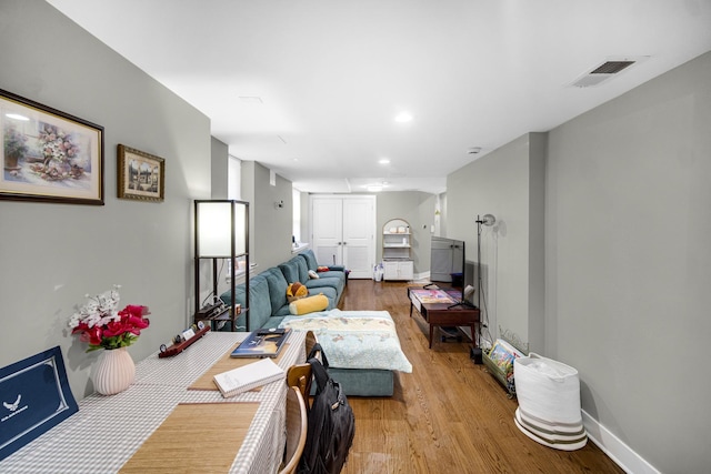 living area featuring light wood finished floors, baseboards, visible vents, and recessed lighting