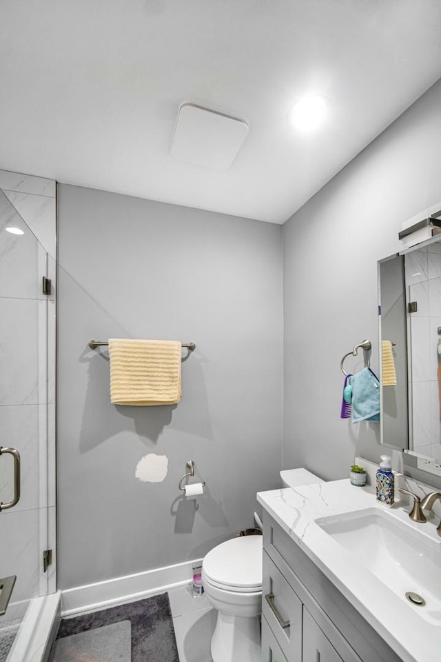 full bathroom featuring toilet, a shower stall, vanity, and baseboards