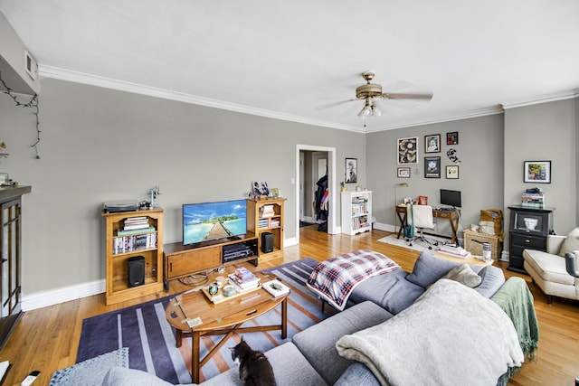 living area with ornamental molding, baseboards, and wood finished floors