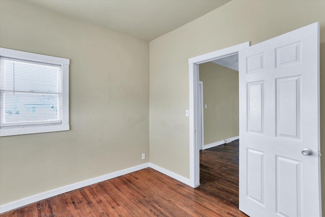 unfurnished room featuring dark wood finished floors and baseboards