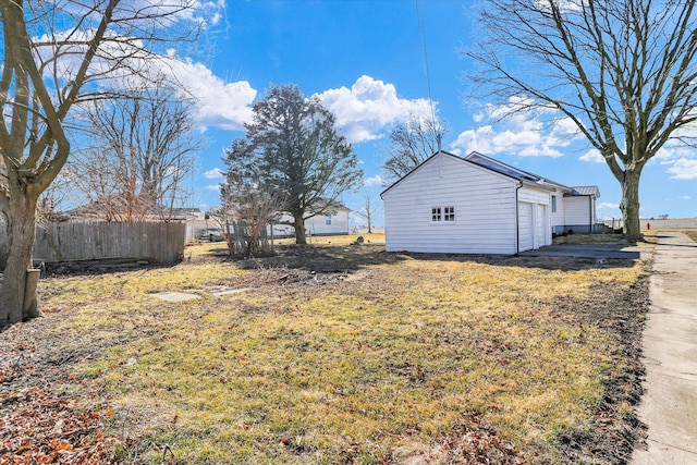 view of yard with a garage, an outdoor structure, and fence