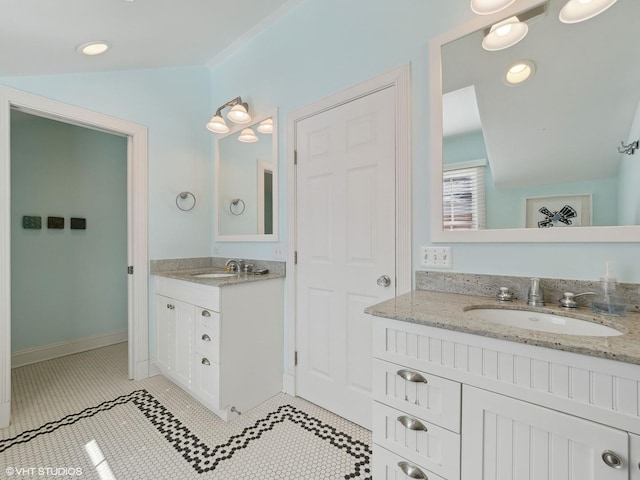 full bath with tile patterned floors, two vanities, baseboards, and a sink