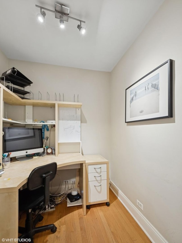 home office with baseboards, wood finished floors, and rail lighting