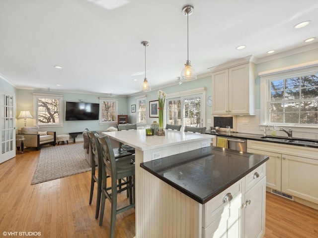 kitchen with a kitchen island, open floor plan, light wood-style flooring, french doors, and a sink