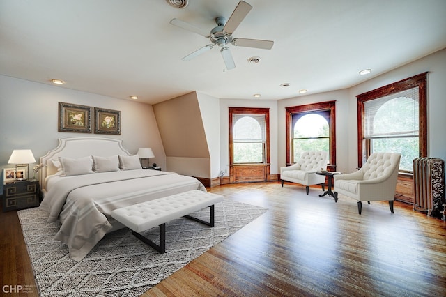 bedroom featuring recessed lighting, visible vents, radiator heating unit, ceiling fan, and wood finished floors