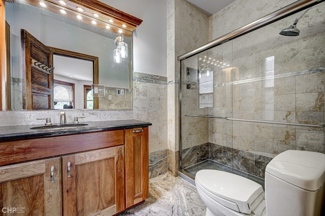 bathroom featuring toilet, marble finish floor, a shower stall, and tile walls