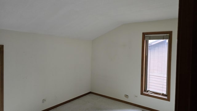 bonus room featuring lofted ceiling, baseboards, light carpet, and a healthy amount of sunlight