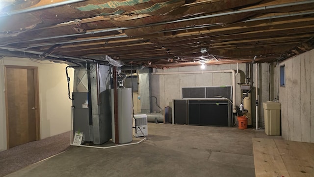 unfinished basement featuring water heater and heating unit